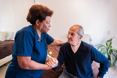 Caregiver helping senior senior man at home
